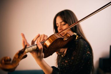 Kız keman çalmaya konsantre oluyor.