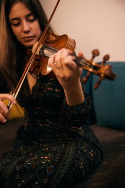 Mutlu kadın en sevdiği siyah elbisesiyle keman çalıyor.