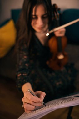 Kemancı notalar yazar, onlara dayanarak keman çalar.