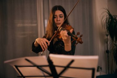 Sınavlara çalışmaya ara verilirken kemancı keman çalıyor ve bundan zevk alıyor.