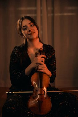 Güzel genç kız kemanıyla poz veriyor.