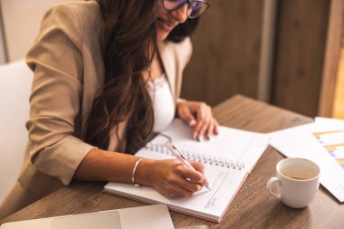 Genç bir kadın mutfaktaki dizüstü bilgisayarda çalışıyor.. 