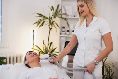 Kadın yapan profesyonel güzellik uzmanı klinikte lazer epilasyonuyla karşı karşıya.. 