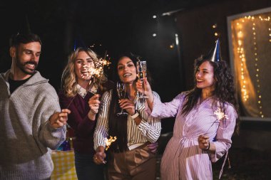 Mutlu arkadaşlar doğum gününü fıskiyelerle kutlar. Neşeli ve gülümserler..