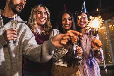 Mutlu arkadaşlar doğum gününü fıskiyelerle kutlar. Neşeli ve gülümserler..