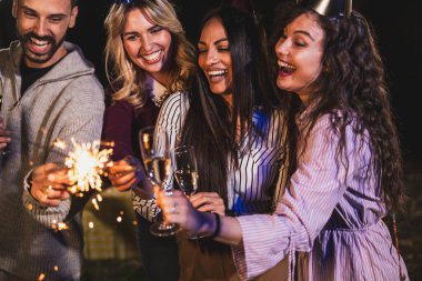 Mutlu arkadaşlar doğum gününü fıskiyelerle kutlar. Neşeli ve gülümserler..