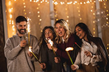 Mutlu arkadaşlar fıskiyelerle kutlarlar, neşeli ve gülümserler..