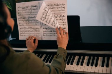 Odaklanırken nota okuyan ve evde yaratıcı fikirleri olan bir kadın.. 