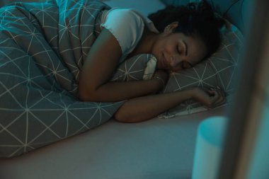 Yatağında yumuşak battaniyelerle uyuyan bir kadın.. 