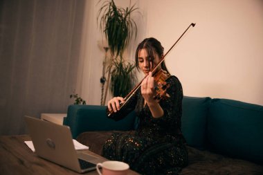 Öğrenci dikkatle dinliyor ve keman çalıyor.