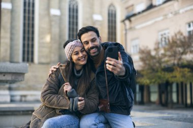 Yeni şehirde selfie çeken gülümseyen turist çift birlikte keşfe çıkıyorlar..