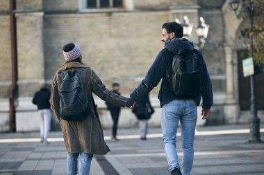 Mutlu, neşeli turist çift el ele tutuşarak şehri keşfediyor ve yeni şehrin tadını çıkarıyor.. 