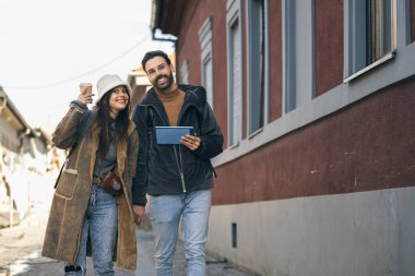 Tablet haritasına bakarken yeni şehri keşfeden gülümseyen turist çift karar veriyor. Sırada ne keşfediyorlar?. 