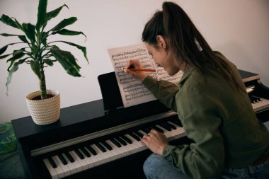 Tutkuyla piyano çalan, eğlenen ve evde bir anı yakalayan genç bir kadın.. 