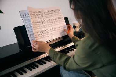 Güzel bir kadın notalara bakıyor ve evinde notlar yazıyor.. 