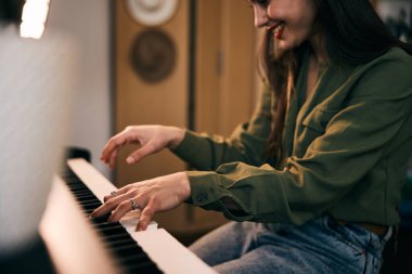 Güzel, gülümseyen bir kadın evde tutkuyla piyano çalıyor.. 