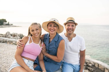 A cheerful family posing together near the beach on beautiful day. 