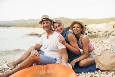 A portrait of happy family at rocky beach having best time together. 