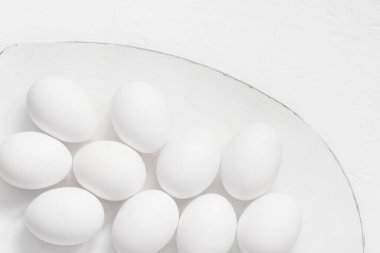 Paskalya arkaplanı: Tabakta beyaz yumurtalar