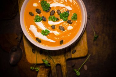 Ekmek arası balkabağı çorbası, maydanoz, kabak tohumu ve krema.