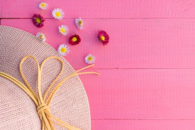 Şapka ve çiçeklerle pembe bahar arkaplanı