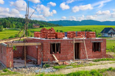 Mountain landscape in spring and construction of a new house