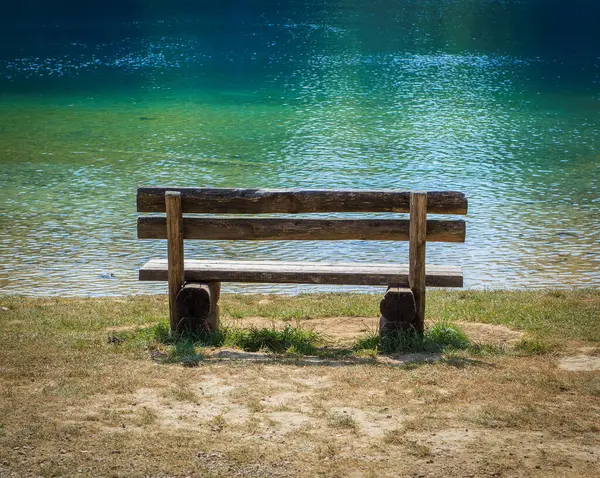 湖边公园里的旧木制长椅 — 图库照片