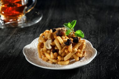 Tatlı tabağının ve siyah arka plandaki fincanların görüntüsünü kapat