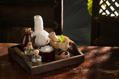 close up view of herb, salt, oil and Herbal Compress on color back.