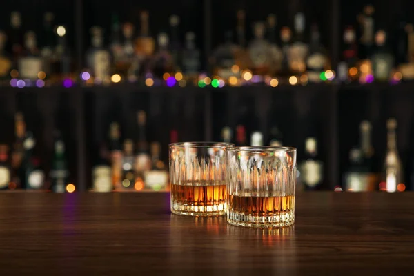 stock image close up view of two glasses with whiskey on color back