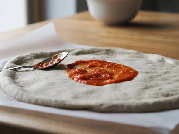 Massa Pizza Crua Uma Placa Madeira Aplicando Molho — Fotografia de Stock