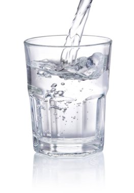 Beyaz arka planda izole edilmiş içme suyu bardağa dökülüyor.