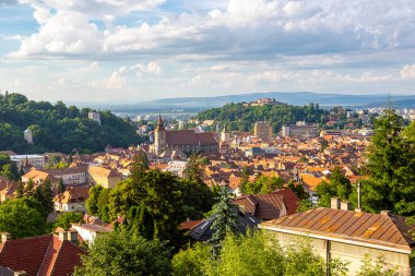 Güneşli bir günde Brasov 'un havadan panoramik görüntüsü. Eski binalarla dolu eski şehir merkezi, yeşillik ve eski kulelerle kaplı tepeler, Brasov, Romanya