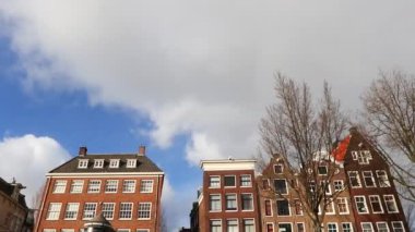 Kanaldan sokaklara yavaş çekim görüntüleri, Amsterdam, Hollanda 'da eski Flaman evleri ve köprüleri olan kanallar.