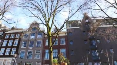 Kanaldan sokaklara yavaş çekim görüntüleri, Amsterdam, Hollanda 'da eski Flaman evleri ve köprüleri olan kanallar.