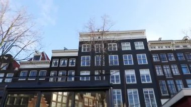 Kanaldan sokaklara yavaş çekim görüntüleri, Amsterdam, Hollanda 'da eski Flaman evleri ve köprüleri olan kanallar.
