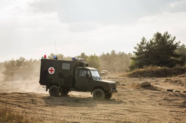 Savaş alanında kırmızı haçla işaretlenmiş askeri araçlar.