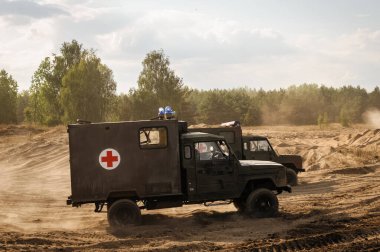 Savaş alanında kırmızı haçla işaretlenmiş askeri araçlar.