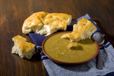 Etli sos kasesi ve ahşap masada İtalyan usulü ekmek.