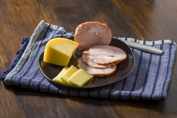 Einfaches Essen Scheiben Käse Und Schinken Auf Einem Schwarzen Teller — Stockfoto