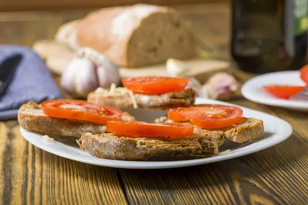 마늘과 토마토 조각으로 퍼지는 올리브 오일의 토스트 스톡 이미지