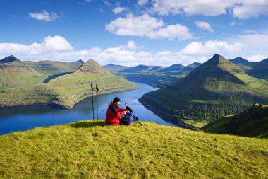Hvithamar Tepesi 'nin tepesinde sırt çantalı bir turist Funningsfjordur Fjord, Eysturoy Adası, Faroe Adaları