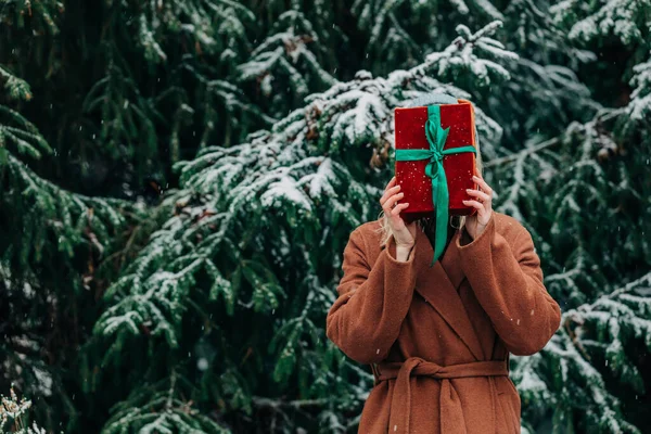 Kobieta Brązowym Płaszczu Ukrywa Się Pudełkiem Świątecznym Śnieżnym Lesie Zimowym — Zdjęcie stockowe