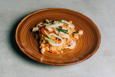 Kahverengi tabakta deniz ürünleri, kalamar ve salatalık.