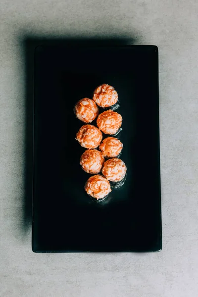 Rollos Sushi Con Salmón Caviar Plato Negro Sobre Fondo Gris — Foto de Stock