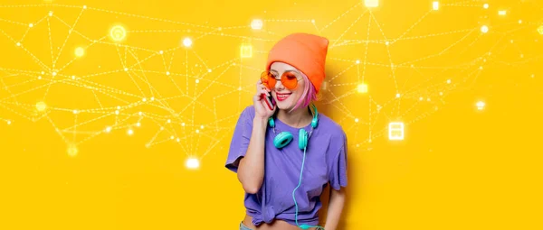 黄色の背景にヘッドフォンや携帯電話で紫色の服の若いスタイルの女の子 1980年代の服装 — ストック写真