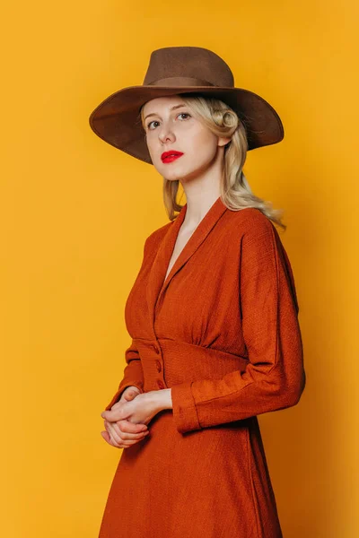 Elegancia Mujer Vestido Marrón Sombrero Sobre Fondo Amarillo Studio Shot —  Fotos de Stock