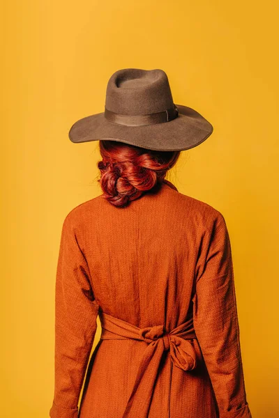 Şık Kızıl Saçlı Şapkalı Sarı Arka Planda Kahverengi Elbiseli Bir Stok Fotoğraf