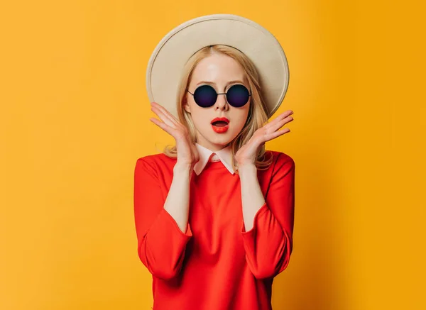 Sarı Arka Planda Kırmızı Elbiseli Güneş Gözlüklü Şık Sarışın Kadın — Stok fotoğraf