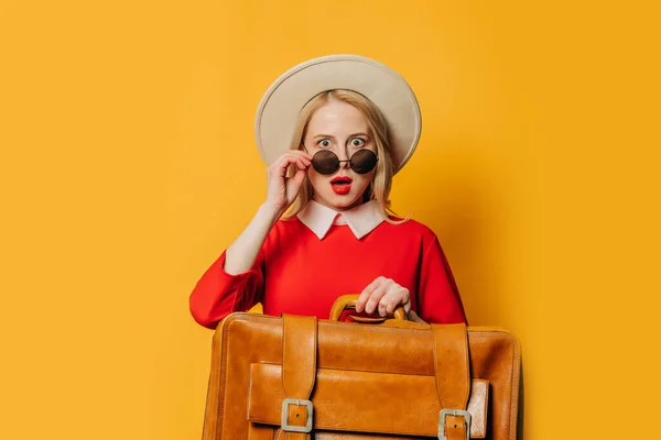 Sarı Arka Planda Bavulu Olan Kırmızı Elbiseli Sarışın Kadın Şaşırdı — Stok fotoğraf